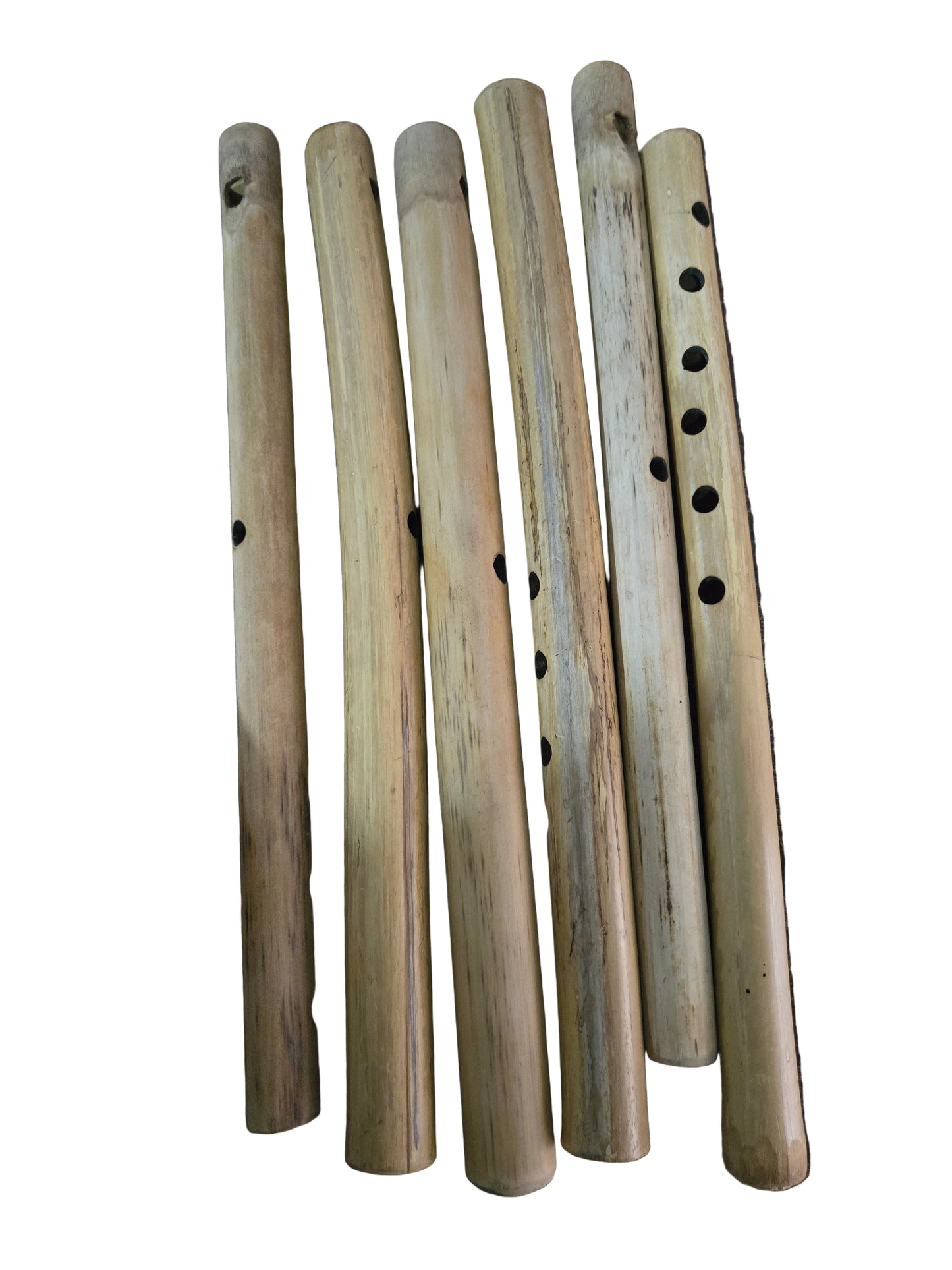Set of wooden flutes on a dark surface with a hand pointing to one of them.
