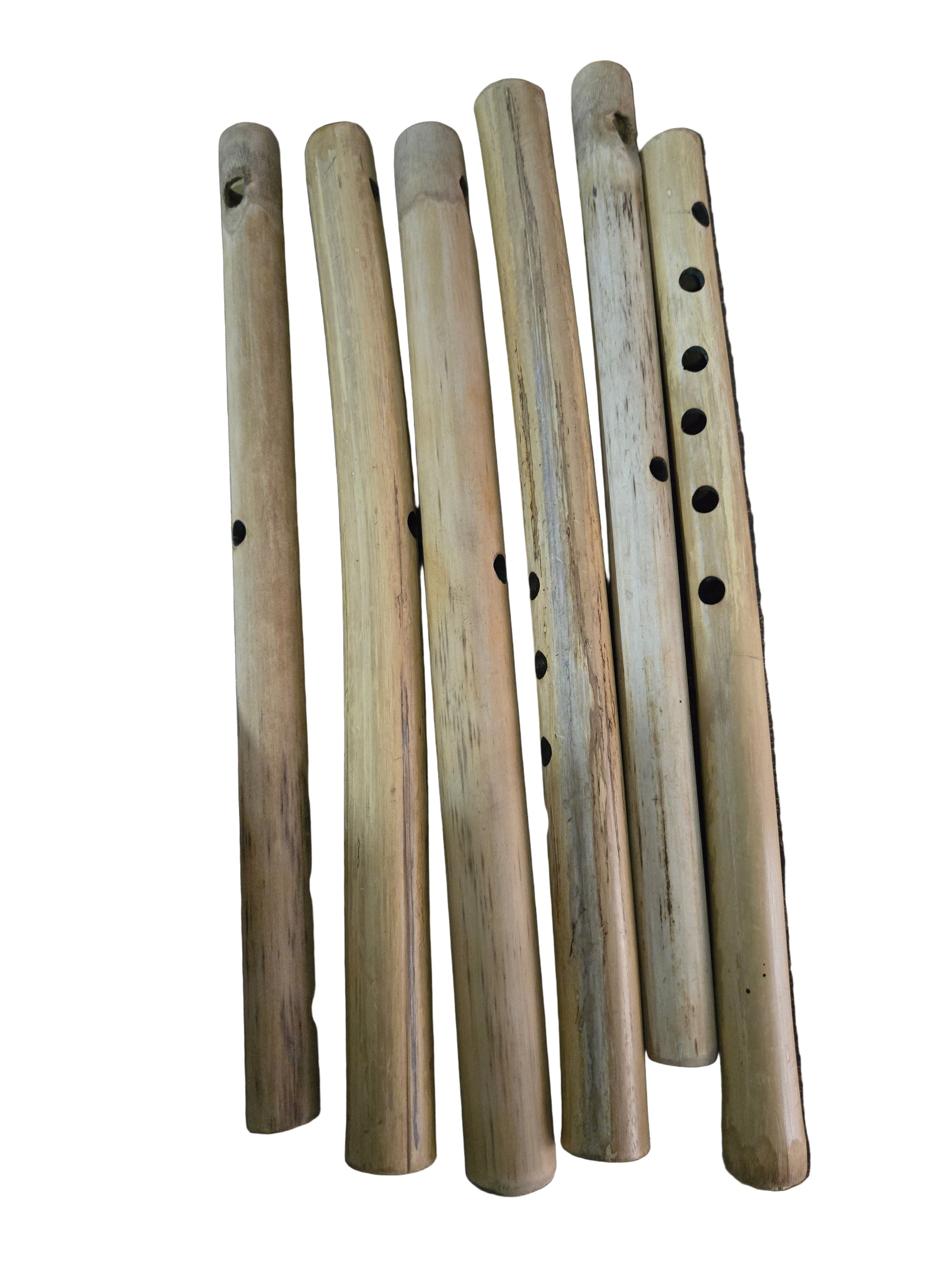 Set of wooden flutes on a dark surface with a hand pointing to one of them.