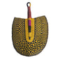 A handmade woven hand fan with a semicircular blade, featuring a yellow and black basketweave pattern with a central vertical stripe of purple, black, and red. The handle is brown wood with a red wrap near the top.
