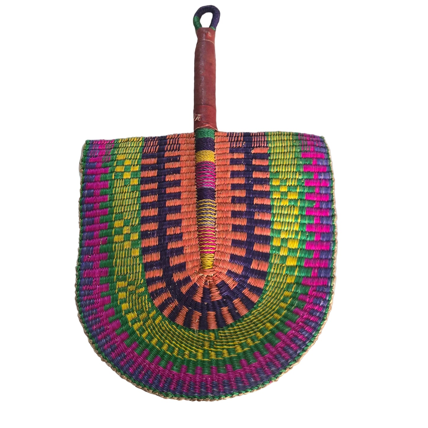 A hand-woven semicircular fan with a wooden handle, featuring vibrant concentric patterns of green, yellow, orange, purple, and pink, resting on a white plastic tub.